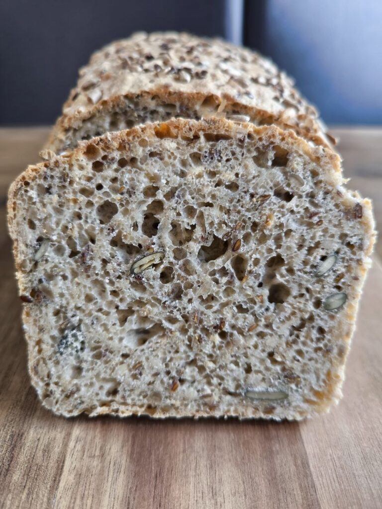 Mehrkornbrot mit Dinkel und Saaten angeschnitten auf Holzbrett